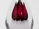 a glass vase with a red flower inside of it