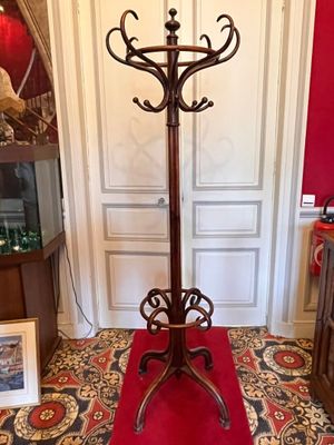 a coat stand in the middle of a room with a red carpet