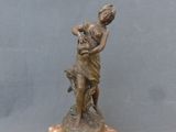 statue en bronze représentant une femme tenant une batte de baseball, posée sur un socle en marbre