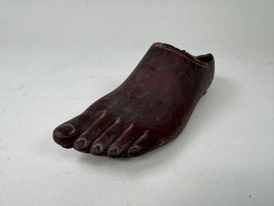 une vieille chaussure posée sur une surface blanche