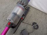 a vacuum that is laying on the floor next to a bed