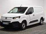 la camionnette blanche est garée dans une pièce au sol en damier