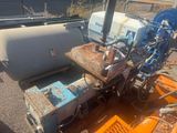 an image of a couple of machines sitting on top of a dirt field