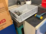 a sink in the corner of a room with boxes and tools