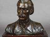 a bronze bust of a man with a mustache on a wooden base