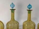 three yellow glass bottles are lined up on a white surface