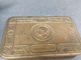 an antique brass cigarette case with a picture of a man on it