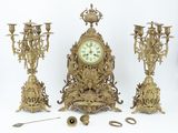 a clock that is sitting next to a bunch of candles