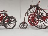 three miniature bicycles sitting next to each other on a white surface