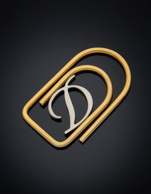 un gros plan d'une broche en or et en argent sur laquelle figure la lettre « d »