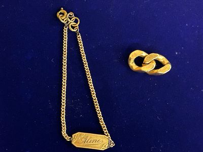two pieces of jewelry are laying on a blue surface