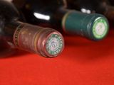 several bottles of wine are lined up on a red surface
