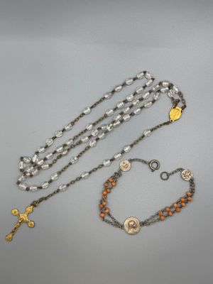 un gros plan d'un chapelet posé sur une table, sur laquelle se trouve une croix