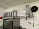 un micro-ondes posé dans une cuisine, avec plein de tasses posées dessus