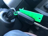 a car key in the center of a car with a green handle