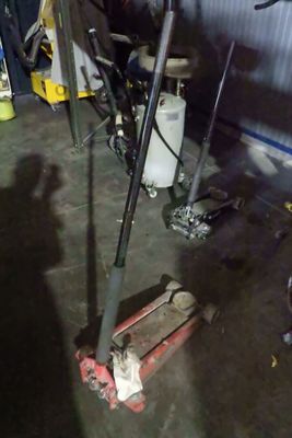 une moto garée dans un garage, avec des outils par terre
