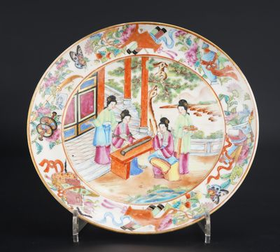 une image représentant une assiette sur laquelle est peinte une femme jouant d'un instrument de musique