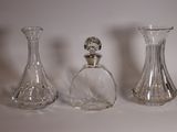 three clear glass vases sitting next to each other on a white surface