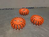 four orange plastic sprinkles sitting on top of a metal surface
