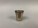 une vieille coupe en argent posée sur une table blanche
