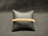 black leather pillow with a gold rope wrapped around it