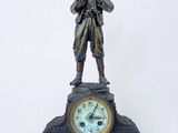 a statue of a man standing on top of a clock next to a pair of scissors