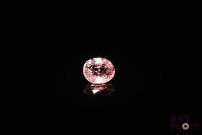 gros plan d'un diamant rose sur une surface noire