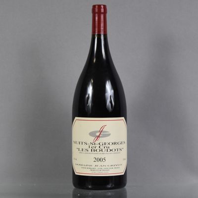 a bottle of red wine sitting on top of a glass table