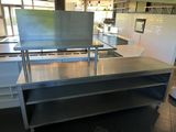 une grande table en acier inoxydable au milieu d'une cuisine