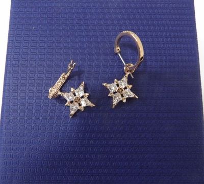 a pair of earrings on a blue background