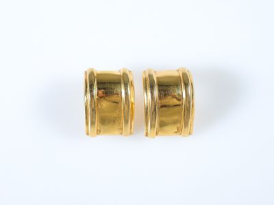 une paire de boucles d'oreilles en or sur fond blanc