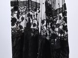 black and white photo of a skirt hanging on a hanger