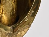 a gold statue of a banana in the middle of a vase
