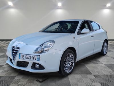La voiture blanche est garée sur le sol à damier de la pièce.