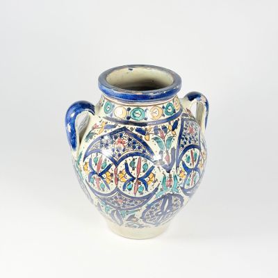 un vase bleu et blanc posé sur une surface blanche