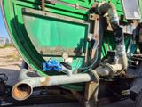 une image représentant un grand camion vert équipé de tuyaux