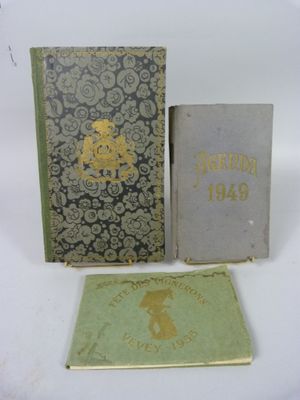 trois livres posés l'un à côté de l'autre sur une surface blanche