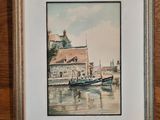 aquarelle encadrée représentant un bateau dans un port, avec une maison en arrière-plan