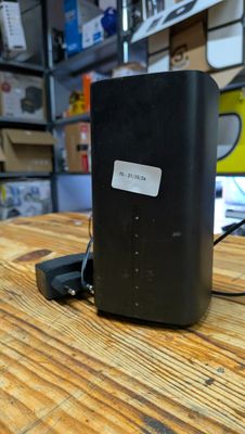 une photo d'un routeur sans fil posé sur une table en bois