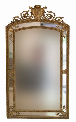 miroir avec un cadre doré et un motif décoratif