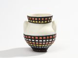 a white vase with a black and orange design on it