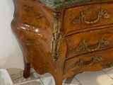 a marble top chest of drawers with a mirror on top
