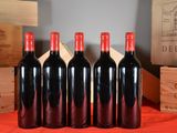 six bottles of red wine are lined up on a table