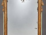 an antique mirror with a gold frame and a bird on it