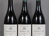 three bottles of wine are lined up on a table