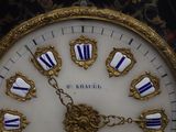 a gold clock with blue and white decorations on it