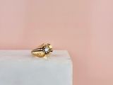 une bague en or posée sur un bloc de marbre blanc