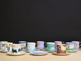 many cups and saucers sitting on a table