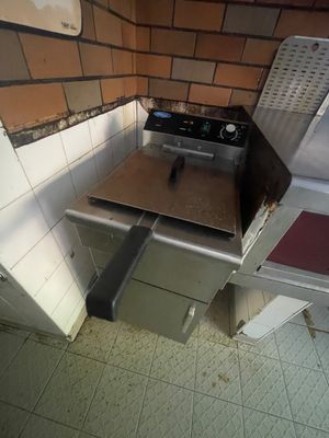 une cuisinière dans un coin d'une cuisine dont le sol est carrelé