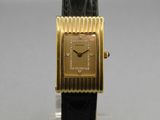 an image of a gold plated wrist watch on a black leather strap